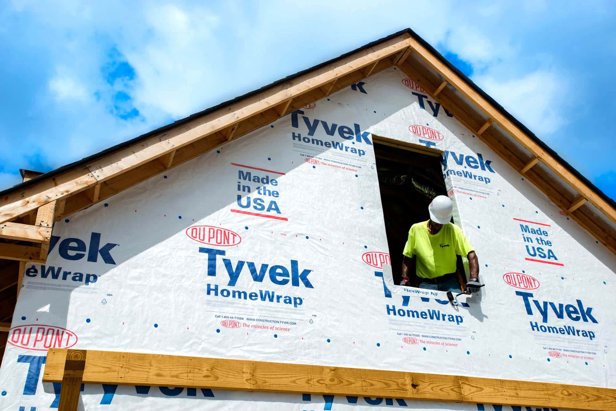 Tyvek Building Wrap with construction worker standing at window on a sunny day